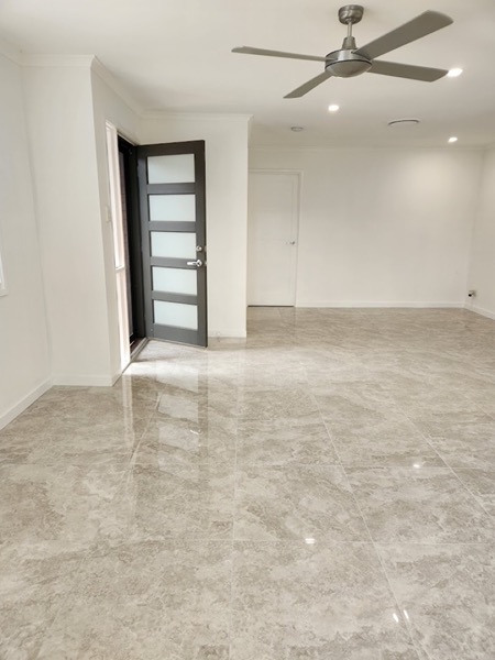 A polished tiled floor in a living room under a ceiling fan
