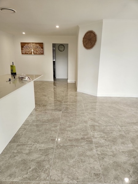 A polished marble-look floor running through an open kitchen and living area